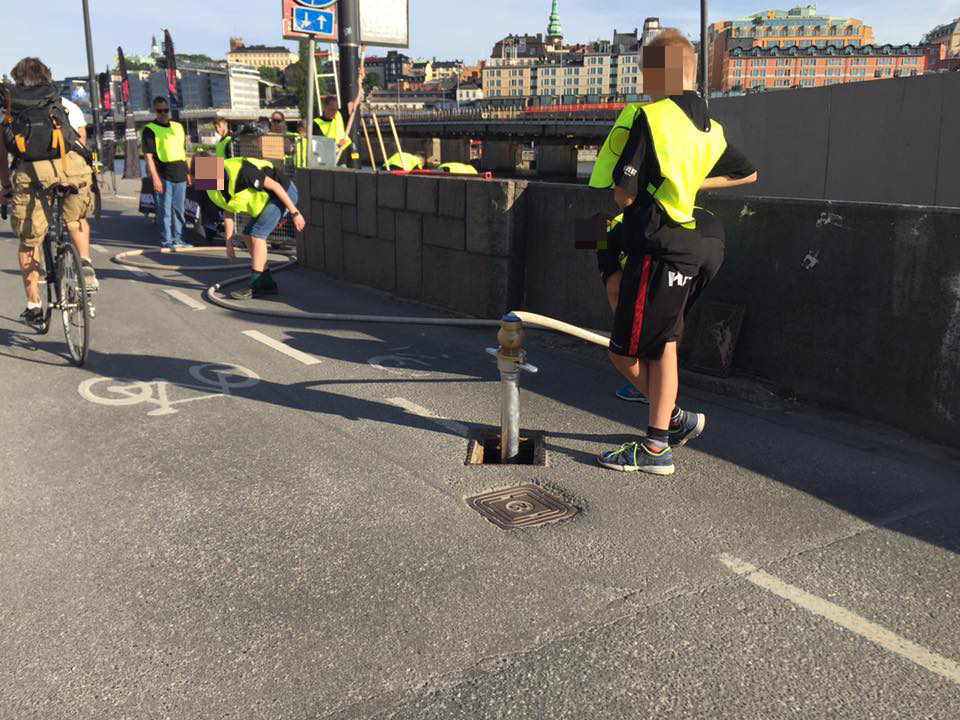 Under kvällen användes barn för att se till att ingen cyklade på vattenslangar och stolpar på den vältrafikerade Munkbroleden. Foto: Jon Jogensjö